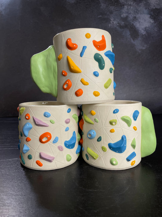 ceramic cup that mimics a climbing wall with a hold handle
